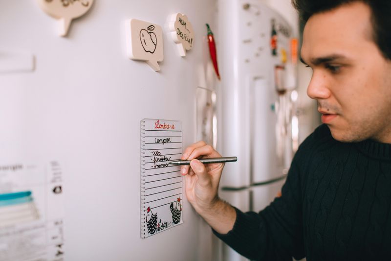 Refrigerator Covered in Magnets and Papers