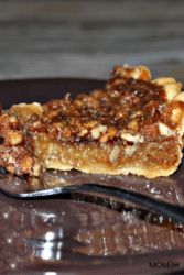 Pie of pecan pie on a plate with a fork