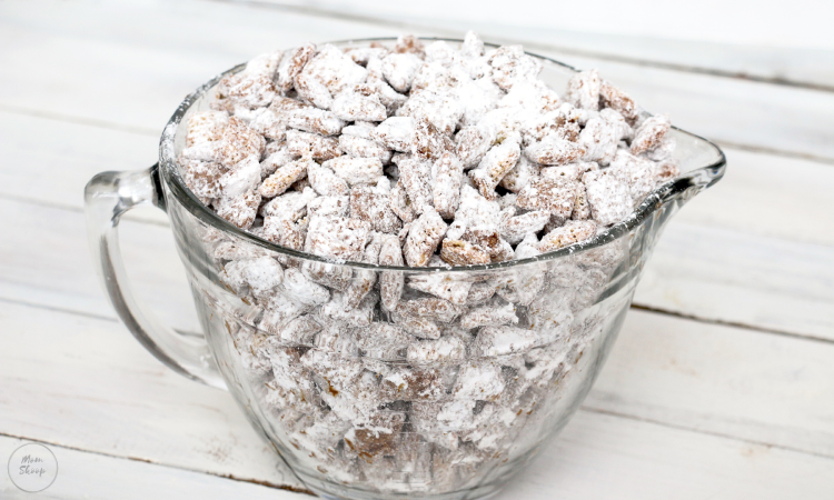 Rice Chex covered in chocolate and powdered sugar in a large glass measuring cup