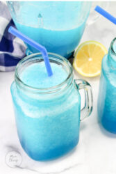 Blue Frozen Party Punch in a glass jar with a straw