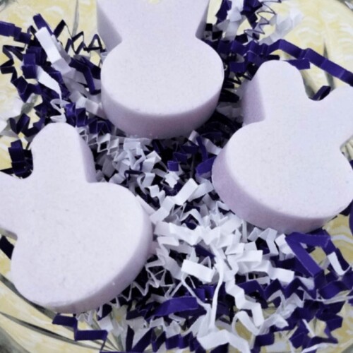 A glass bowl full of three Lavender Bunnies made from sugar scrub