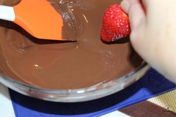Dipping strawberries into melted chocolate