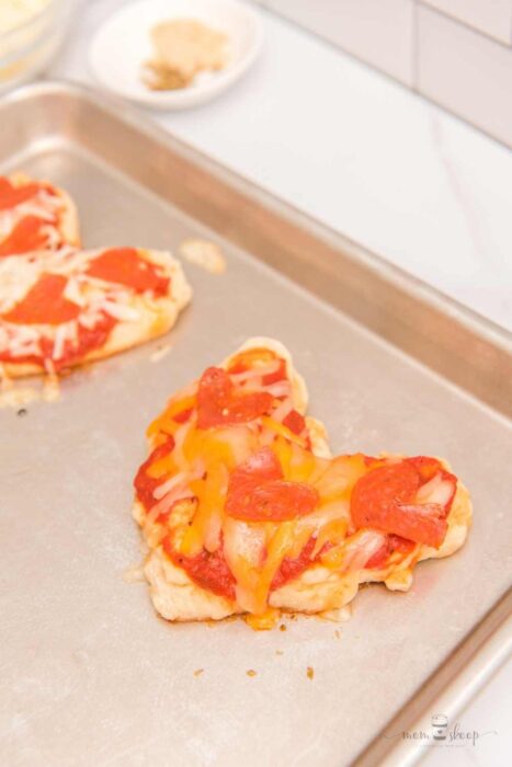 Baked heart shaped pizza topped with pepperoni and cheese.