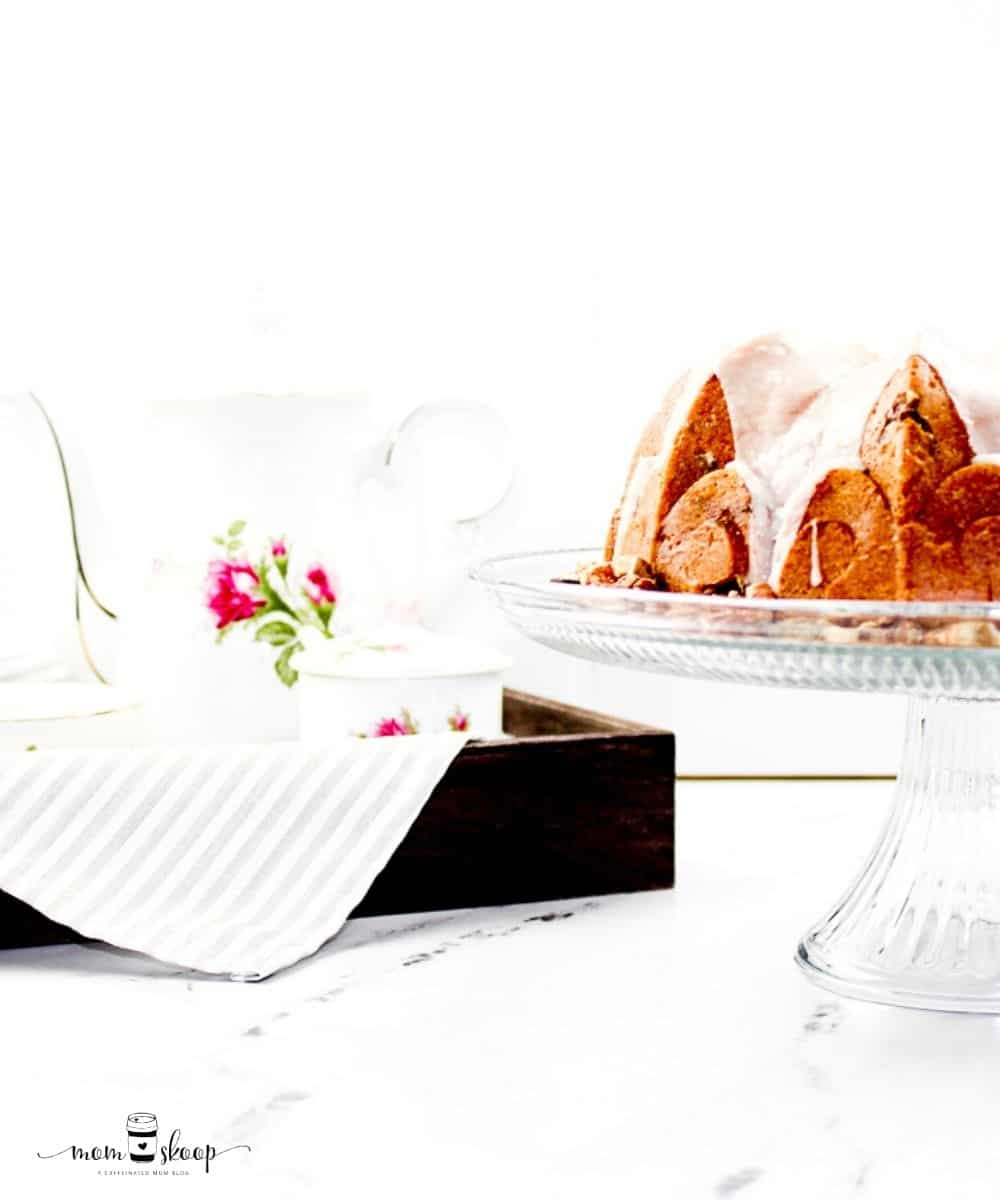 Bundt cake with sour cream and pecans on a glass stand