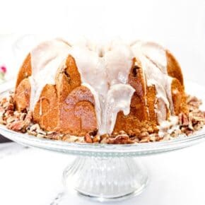 Pecan Bundt Cake on a glass stand and topped with glaze