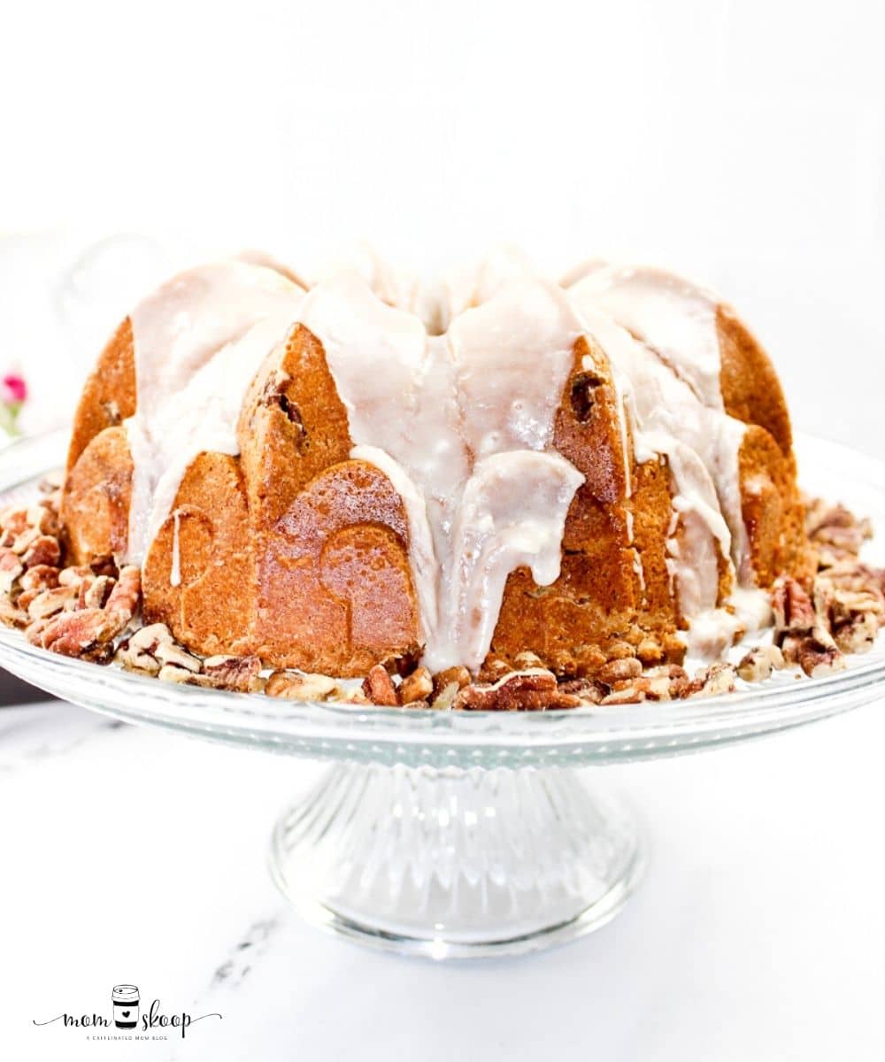 Pecan Bundt Cake on a glass stand and topped with glaze