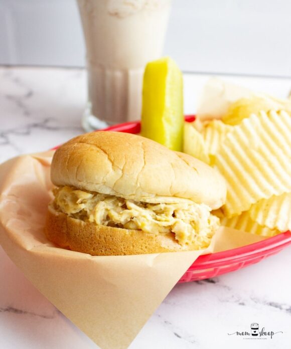 Hot Shredded Chicken Sandwich with chips and a kosher pickle