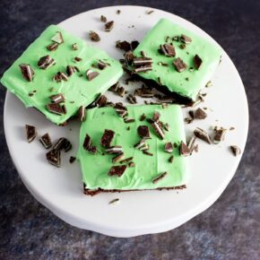 A white cake stand topped with three Andes Mint Brownies