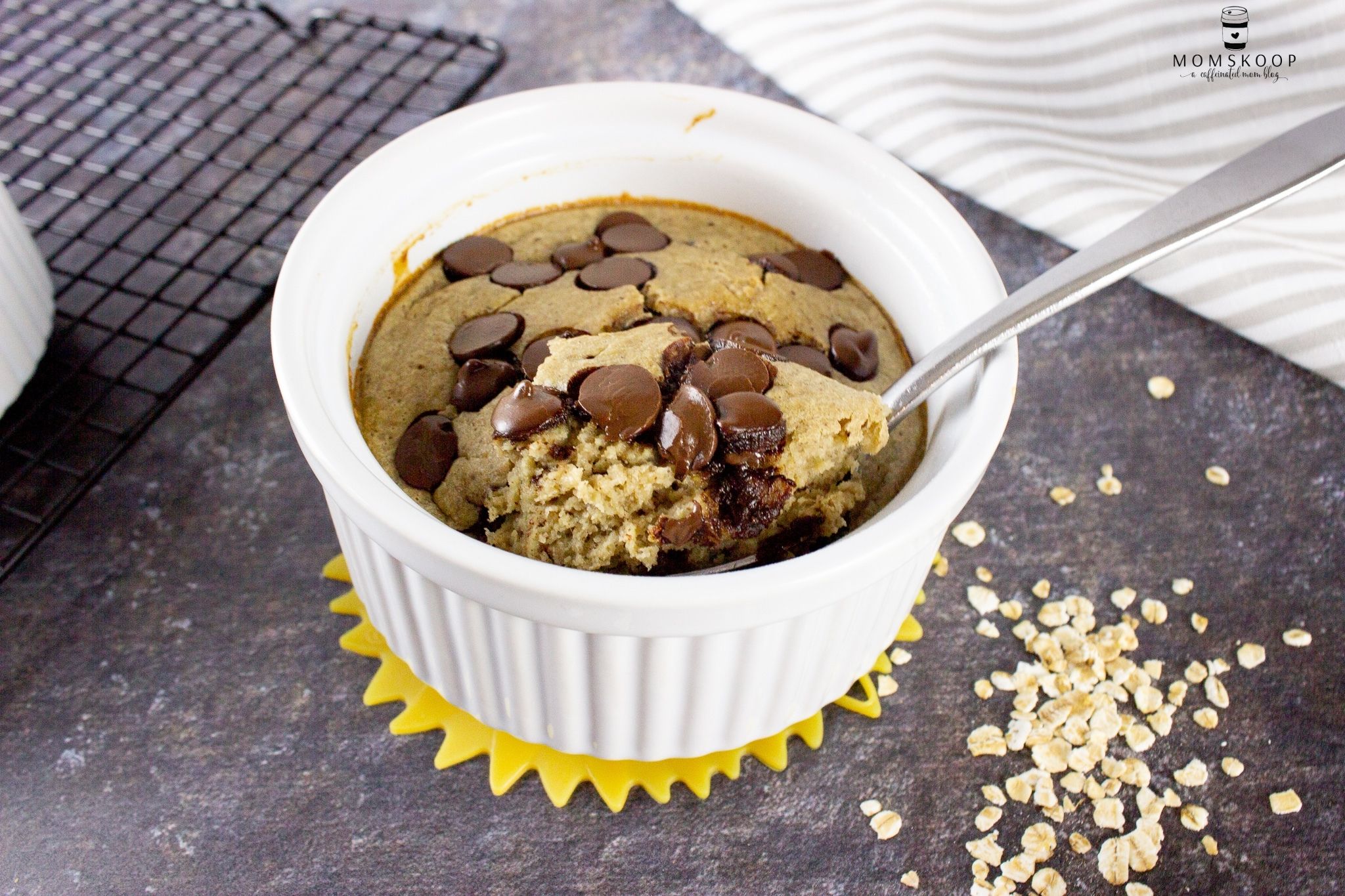 A white ramekin full of blended baked oats and topped with chocolate chips