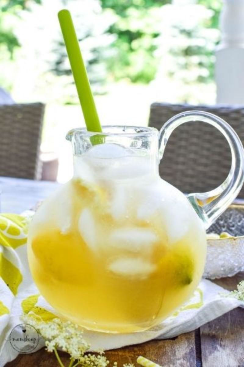 A large glass pitcher full of Elderflower lemonade with ice cubes