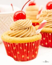 Cupcakes made with root beer and topped with frosting and a cherry