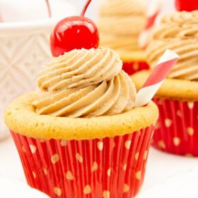 Cupcakes made with root beer and topped with frosting and a cherry