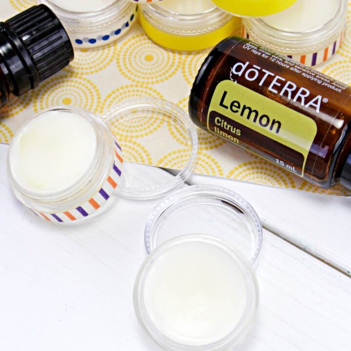mini containers of DIY Lip Balm with bottles of essential oils.