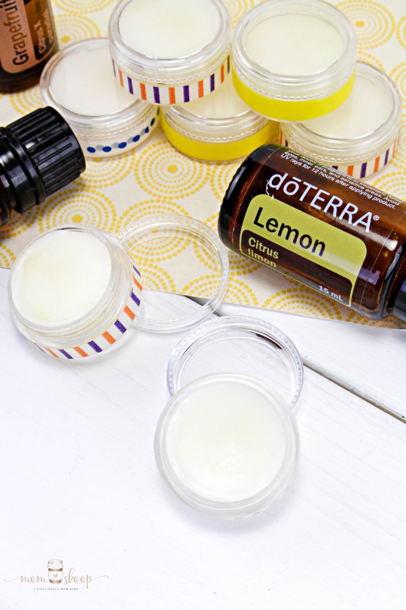 mini containers of DIY Lip Balm with bottles of essential oils.