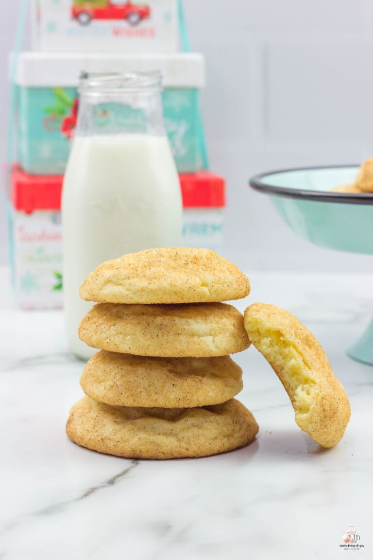 5 Snickerdoodle cookies stacked on top of each other with a glass of milk.