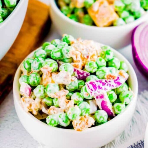 Peas, cheese, and mayo in a small white bowl.
