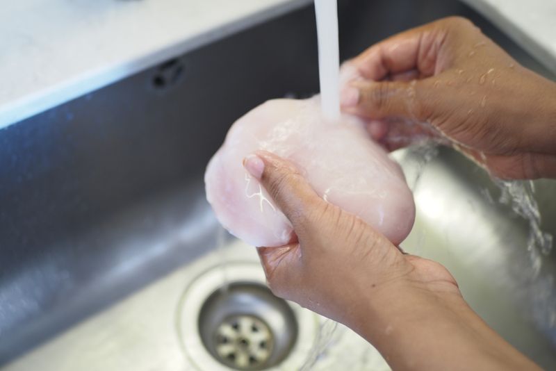 Washing raw chicken in the sink